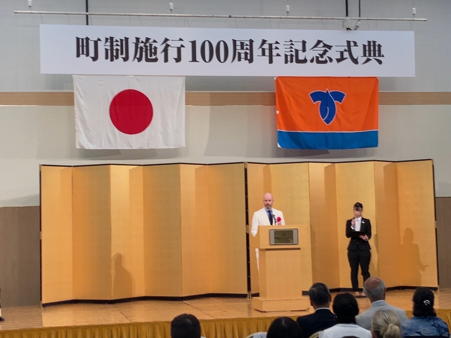軽井沢町町制施行100周年式典でウィスラー市長代理が祝辞を述べている写真