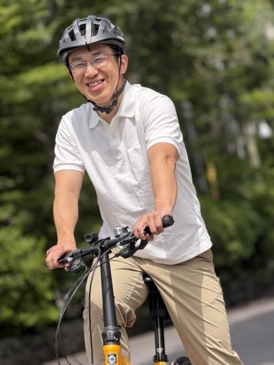 ヘルメットを着用し自転車に乗る人